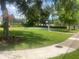 Outdoor community basketball court with green lawn, bench, and tree shade for recreational enjoyment at 9509 Baycliff Ct, Orlando, FL 32836