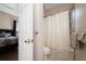 Bathroom access from a bedroom featuring a tiled shower/tub combo with a shower curtain and hardwood floors at 9509 Baycliff Ct, Orlando, FL 32836
