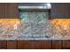 Close up of a modern kitchen featuring granite countertops and backsplash with stylish cabinets and stainless steel hood at 9509 Baycliff Ct, Orlando, FL 32836
