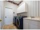 Laundry room with striped wallpaper, tile floors, modern washer and dryer, and a utility sink at 9509 Baycliff Ct, Orlando, FL 32836