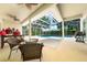 Screened pool enclosure featuring seating area and outdoor grill, with beautiful natural light and garden views at 9509 Baycliff Ct, Orlando, FL 32836