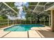 Screened pool enclosure featuring a heated pool with garden views for ultimate relaxation and entertainment at 9509 Baycliff Ct, Orlando, FL 32836