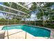 Sparkling pool inside a screened enclosure with lush garden surroundings ensures a private oasis at 9509 Baycliff Ct, Orlando, FL 32836