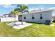 Well-manicured backyard features palm trees, a stone paver patio, a privacy fence, and a lush lawn at 1180 Lone Palm Way, St Cloud, FL 34771