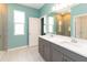 Bright bathroom features a double vanity, quartz countertop, grey cabinets, and tiled walk-in shower at 1180 Lone Palm Way, St Cloud, FL 34771