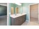 Bathroom with double vanity sinks, modern lighting, and access to the walk-in closet at 1180 Lone Palm Way, St Cloud, FL 34771