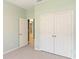 Bedroom featuring carpeted floors, a closet, and a door leading to other parts of the house at 1180 Lone Palm Way, St Cloud, FL 34771