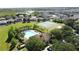 Wide aerial view of the neighborhood, community pool, tennis courts, and wooded area at 1271 Yorkshire Ct, Davenport, FL 33896