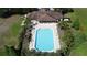 An aerial view of a well maintained pool with lounge chairs next to a building with lush landscaping at 1271 Yorkshire Ct, Davenport, FL 33896