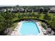 Aerial view of a beautiful pool area with many lounge chairs, surrounded by palm trees and landscaping at 1271 Yorkshire Ct, Davenport, FL 33896