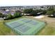 Aerial view of neighborhood outdoor tennis courts with green playing surface and surrounding residential area at 1271 Yorkshire Ct, Davenport, FL 33896