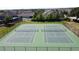 Aerial view of outdoor tennis courts with a green playing surface and high fences at 1271 Yorkshire Ct, Davenport, FL 33896