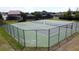 Aerial view of outdoor tennis courts featuring well-maintained green playing surfaces and a surrounding security fence at 1271 Yorkshire Ct, Davenport, FL 33896