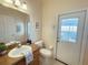 Cozy bathroom featuring a single vanity, toilet, and door leading to the outside at 141 Summer Place Loop, Clermont, FL 34714
