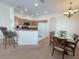 Open concept kitchen with light wood cabinets, bar seating, and an adjacent dining area at 141 Summer Place Loop, Clermont, FL 34714