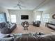 Open-concept living area with plush seating, a ceiling fan, and a large TV for entertainment at 141 Summer Place Loop, Clermont, FL 34714