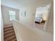 Carpeted staircase leading to the bedrooms with natural light and a view into the main bedroom at 141 Summer Place Loop, Clermont, FL 34714