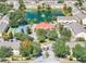 Aerial view showcases a pond with fountain, clubhouse, and tennis court amenities in the community with lush trees at 2804 Club Cortile Cir # A, Kissimmee, FL 34746