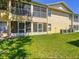 Exterior of a two-story condo building featuring screened patios, green grass lawn and multiple air conditioning units at 2804 Club Cortile Cir # A, Kissimmee, FL 34746
