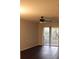 An empty living room with sliding glass doors, a ceiling fan and hardwood floors at 2804 Club Cortile Cir # A, Kissimmee, FL 34746