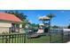 Community playground with modern equipment, lush green turf and black metal fencing surrounding the play area at 2804 Club Cortile Cir # A, Kissimmee, FL 34746