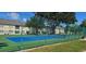 Bright blue and green community tennis court surrounded by a tall chain link fence and mature landscaping at 2804 Club Cortile Cir # A, Kissimmee, FL 34746