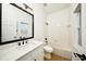 Bathroom with white cabinets, quartz countertops and black hardware, as well as a shower-tub combo with white tiled walls at 3600 Harbor Isles Ct, Kissimmee, FL 34746