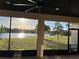 Stunning screened-in patio view of a lake with beautiful landscaping, and the sun reflecting on the water at 3600 Harbor Isles Ct, Kissimmee, FL 34746