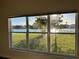Beautiful window view of a lake with lush landscaping and neighboring houses in the distance at 3600 Harbor Isles Ct, Kissimmee, FL 34746