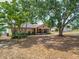 Single story home featuring a screen porch, traditional shutters, and mature trees at 629 N 7Th St, Lake Wales, FL 33853