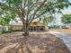 Quaint single-story home with a screened-in front porch and a large shade tree at 629 N 7Th St, Lake Wales, FL 33853