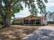 Wide angle shot of single-story home with large shade tree in the front yard at 629 N 7Th St, Lake Wales, FL 33853
