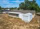 Rear view of the single-story home with a screened-in porch and a detached garage at 629 N 7Th St, Lake Wales, FL 33853