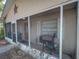 View of screened porch with chairs, grill, and home's front door at 629 N 7Th St, Lake Wales, FL 33853