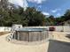 Backyard with above ground pool featuring concrete surround, shade trees, and a fenced perimeter at 6922 Doehring Dr, Lakeland, FL 33810