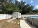 Backyard featuring a shed on a concrete platform next to a pool with privacy fencing at 6922 Doehring Dr, Lakeland, FL 33810