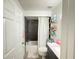 Bathroom with shower-tub, floating shelves, granite vanity top and white floral patterned floor mat at 6922 Doehring Dr, Lakeland, FL 33810