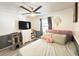 Bedroom featuring a decorative ceiling fan, a plush bed with pink headboard and wall with gray accent at 6922 Doehring Dr, Lakeland, FL 33810