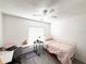 Bedroom with a ceiling fan, desk, and pink bed with white metal frame and grey floors at 6922 Doehring Dr, Lakeland, FL 33810