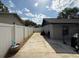 Long driveway along side of house features a wooden barrel planter, fence, and exterior of home at 6922 Doehring Dr, Lakeland, FL 33810