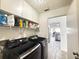 Laundry room with black Samsung washer and dryer and white cabinets and open door to kitchen at 6922 Doehring Dr, Lakeland, FL 33810