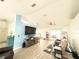 An open living room with vaulted ceilings, wood-look tile, large television, and a sliding glass door at 6922 Doehring Dr, Lakeland, FL 33810