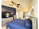 Comfortable main bedroom with wood-look tile floors, ceiling fan, art, television, and an ensuite bathroom at 6922 Doehring Dr, Lakeland, FL 33810
