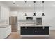 An open-concept kitchen features white cabinets, stainless steel appliances and an island with bar seating at 8352 Lookout Pointe Dr, Windermere, FL 34786