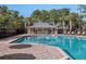 Large community pool with a brick deck, gazebo, lounge chairs, and clear blue water at 8352 Lookout Pointe Dr, Windermere, FL 34786