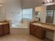 Well-lit bathroom featuring a soaking tub, double vanities, granite countertop, and glass-enclosed shower at 2550 Bella Vista Dr, Davenport, FL 33897