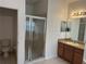 Bright bathroom featuring a glass shower door, single sink vanity, and neutral tile flooring at 2550 Bella Vista Dr, Davenport, FL 33897