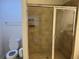 Bathroom with tan tile and a glass shower door at 2550 Bella Vista Dr, Davenport, FL 33897