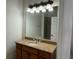 Bathroom with granite countertop, wooden vanity, and Hollywood style lighting above large mirror at 2550 Bella Vista Dr, Davenport, FL 33897