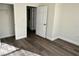 Bedroom with wood-look flooring, white trim, and access to closet and other rooms at 2550 Bella Vista Dr, Davenport, FL 33897